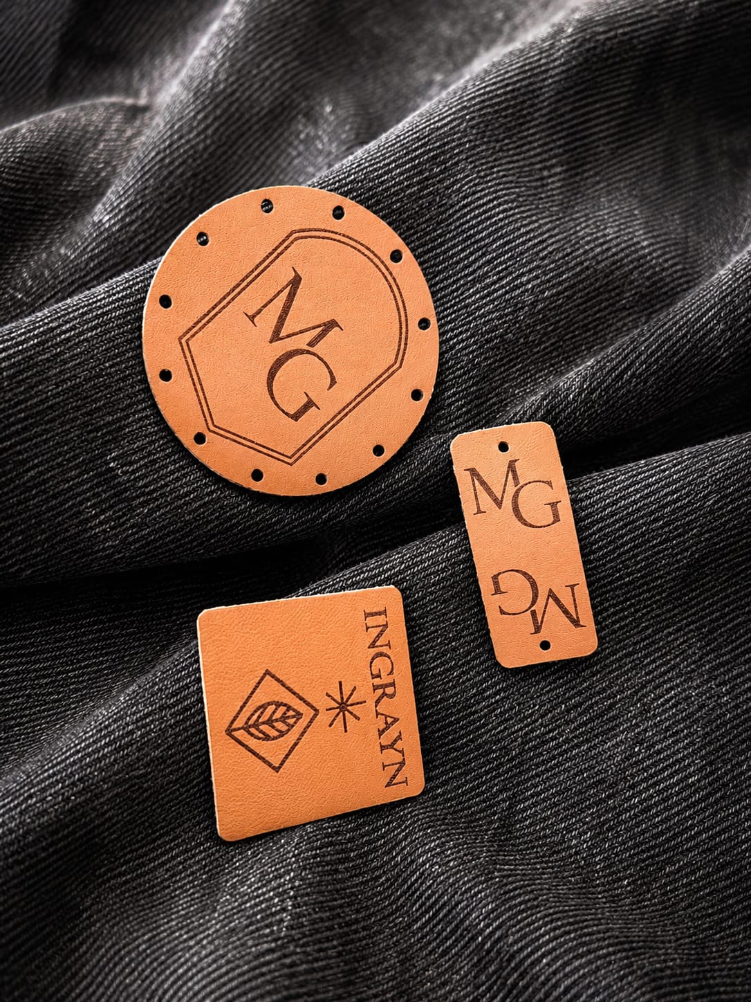 Drie verschillende labels liggend op donker denim