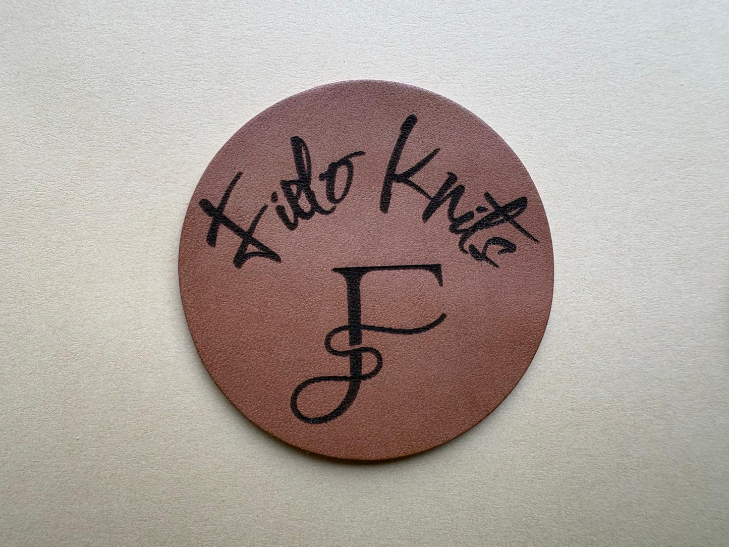 Groot rond leren label met ontwerp fielo knits